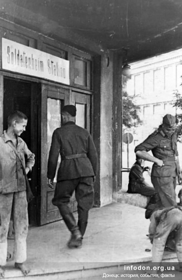 Вход в первый гастроном. Сталино, годы оккупации, 1942-43 гг. Мальчишки чистят обувь немецким солдатам за деньги